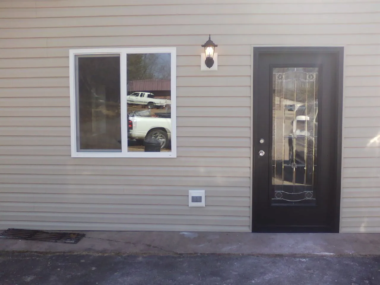 New siding, window and entry door on the side of an addition in Rush